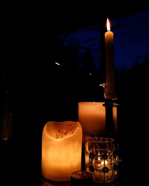 Foto velas iluminadas en el cuarto oscuro