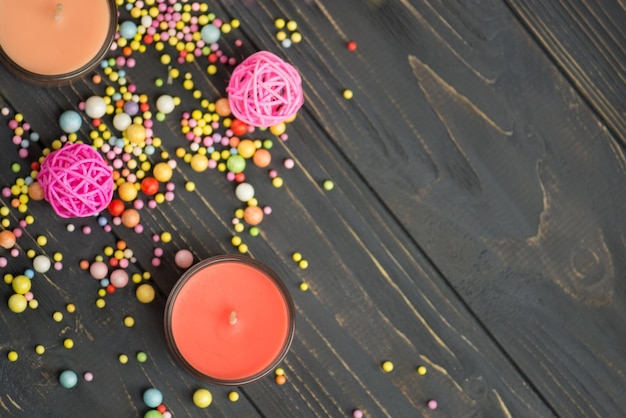 Velas laranja e estrelas de papel em um fundo preto de madeira