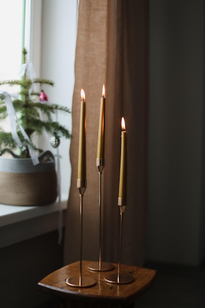 Foto velas longas pintadas de cor dourada em mesa de madeira em casa composição interior moderna da sala de estar