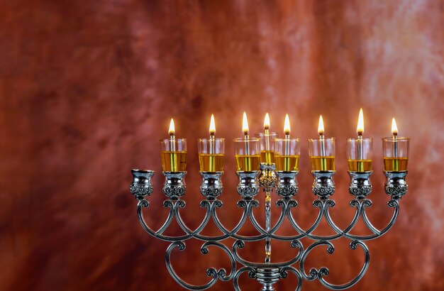 Las velas de Menorah Hanukkah están encendidas en Hanukkiah en la luz de los siete días festivos.