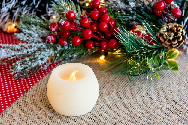 Velas en una mesa de Navidad con adornos navideños.