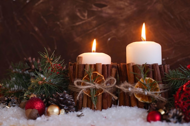 Las velas de Navidad decoradas con canela, papas fritas de naranja y una ramita de romero