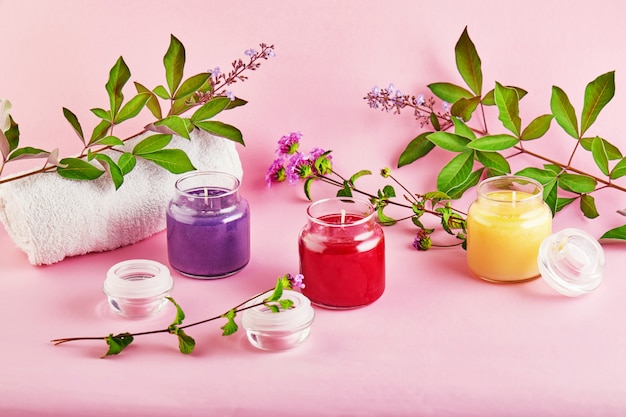 Velas perfumadas para Spa e casa com folhas verdes em um espaço rosa.