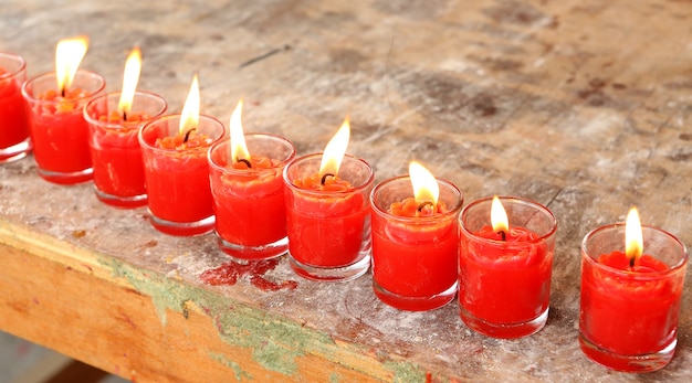 velas rojas alineadas ardiendo en vidrio