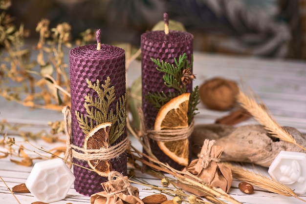 Velas roxas decorativas feitas de cera de abelha com aroma de mel para interior e tradição.