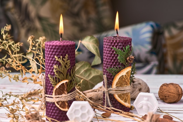 Velas roxas decorativas feitas de cera de abelha com aroma de mel para interior e tradição.