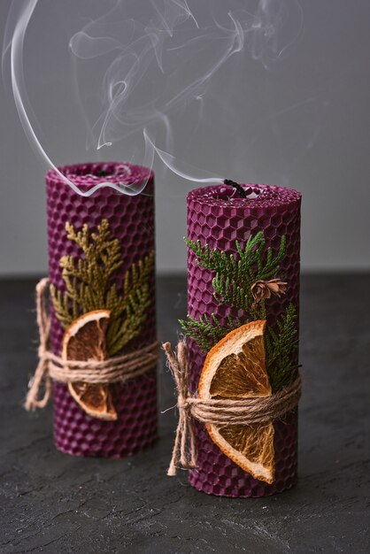 Velas roxas decorativas feitas de cera de abelha com aroma de mel para interior e tradição.