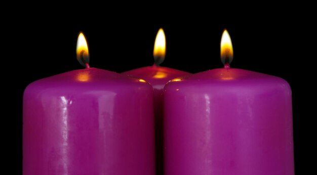 Velas roxas em fundo preto
