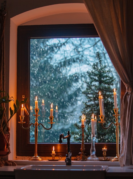 Velas en la ventana de la cocina durante una nevada