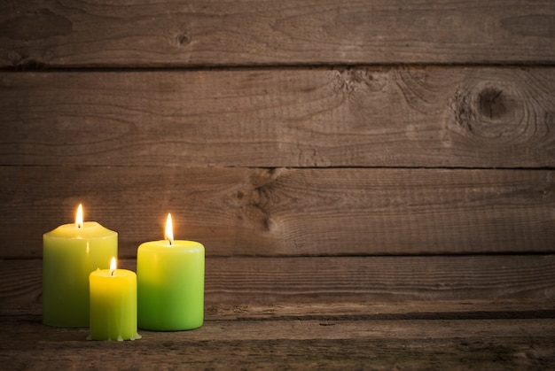 Velas verdes sobre fondo de madera oscura