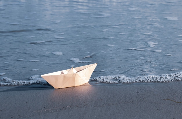 Veleiro de papel origami embarcando em uma jornada para o mar