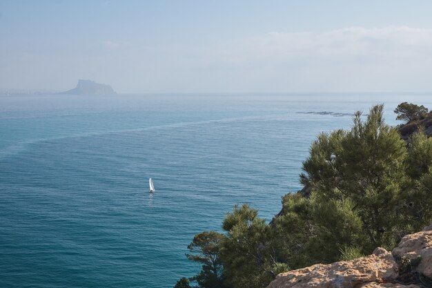 Veleiro navegando em um dia ensolarado vista do mar do topo de uma montanha