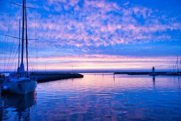 Veleiro no porto do lago Vaettern ao pôr do sol Farol ao fundo