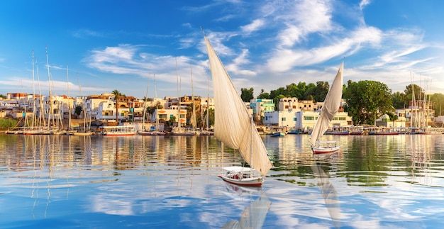 Veleiros no nilo e edifícios tradicionais de aswan egito