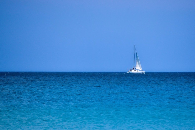 Velero en cielo despejado y mar tranquilo