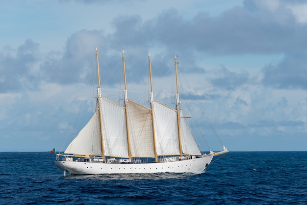 Velero con cuatro velas blancas.