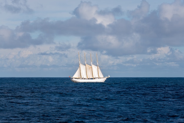 Velero con cuatro velas blancas.