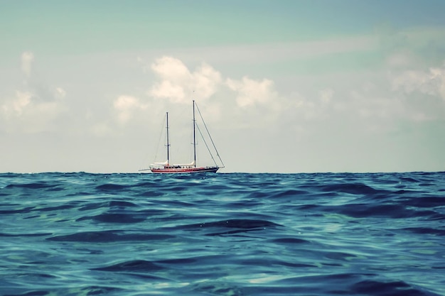 Velero de madera navegando en el horizonte mar abierto azul