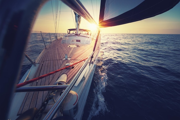 Velero navegando en el mar durante la puesta del sol