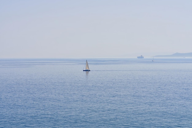 El velero solitario en el horizonte en el mar