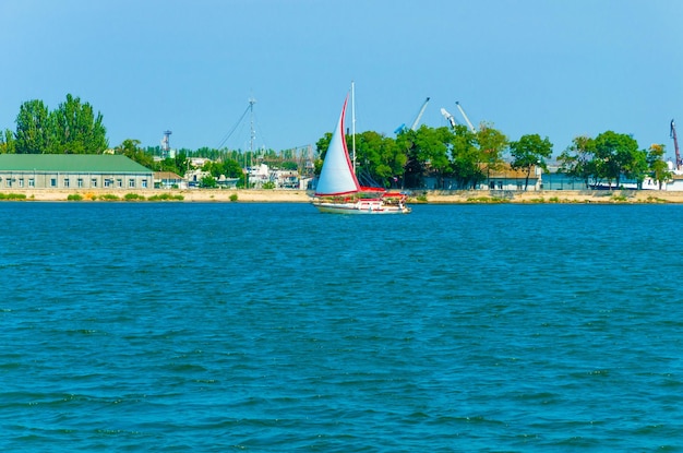 Foto un velero con una vela blanca está en el agua.