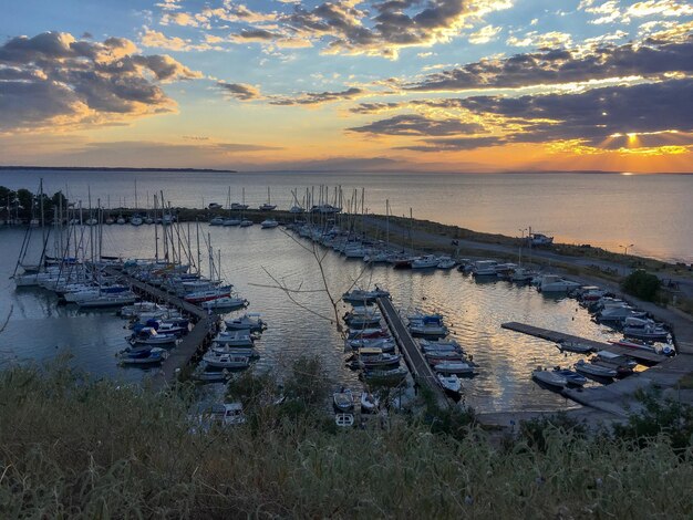 Foto los veleros amarrados en el mar contra el cielo durante la puesta de sol