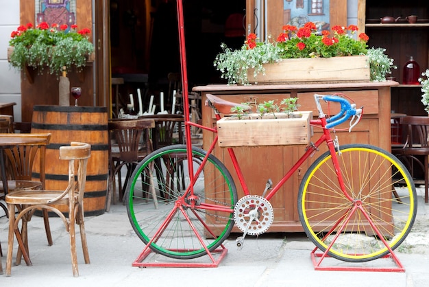 Velha bicicleta colorida carregando flores na rua café na cidade de Lvov