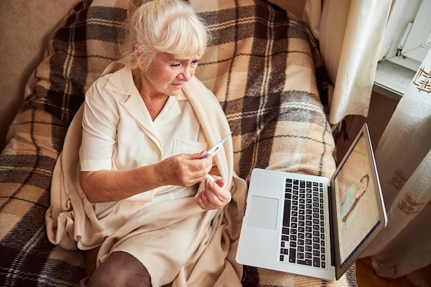 Velha doente tendo consulta online com médico em casa