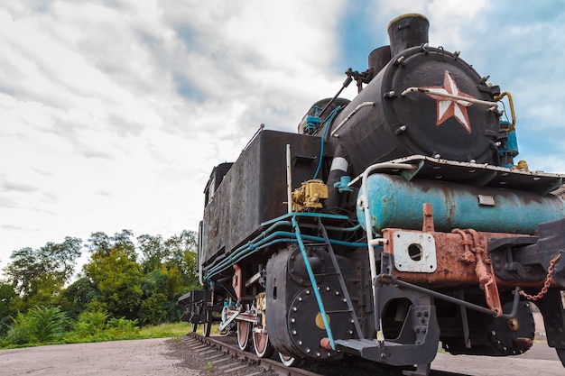 Velha locomotiva a vapor enferrujada parada nos trilhos