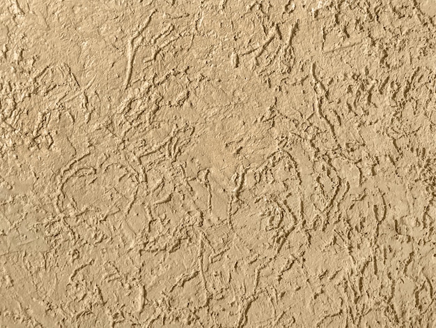 Velha parede bege coberta com fundo de gesso irregular