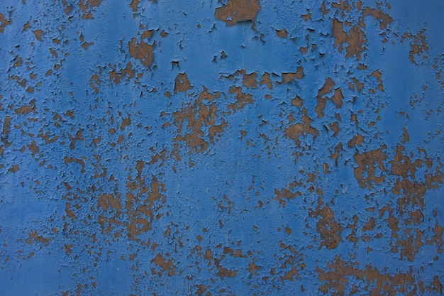 velha parede enferrujada de ferro pintada com tinta azul, que está rachada pelo tempo e pelo clima