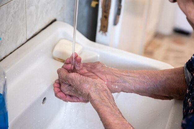 Velha senhora lavando as mãos