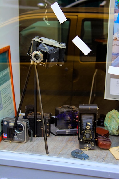 Foto velhas câmeras na loja vistas através de uma janela de vidro com reflexo