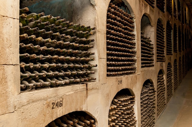 Velhas garrafas de vinho empilhadas em fileiras