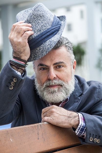 Velho atraente com barba e chapéu