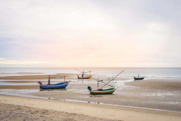 Velho barco de pesca de madeira na praia de Hua Hin