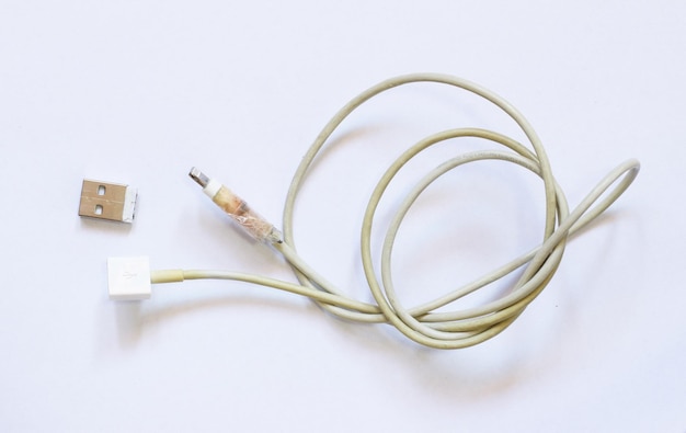 Velho cabo de carregador quebrado USB em fundo branco