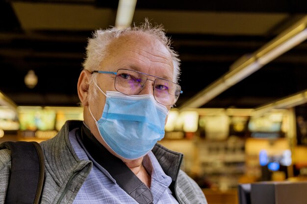 Foto velho com máscara médica em pé no metrô