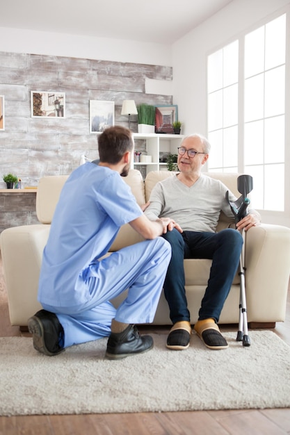 Foto velho com saúde mental reconhece seu médico no lar de idosos. zelador conversando com o velho.