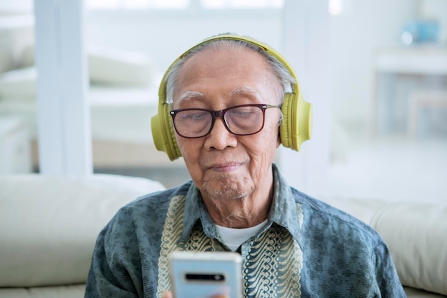 Velho curtindo música com um telefone