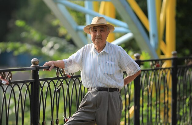 velho de chapéu descansando ao ar livre no verão