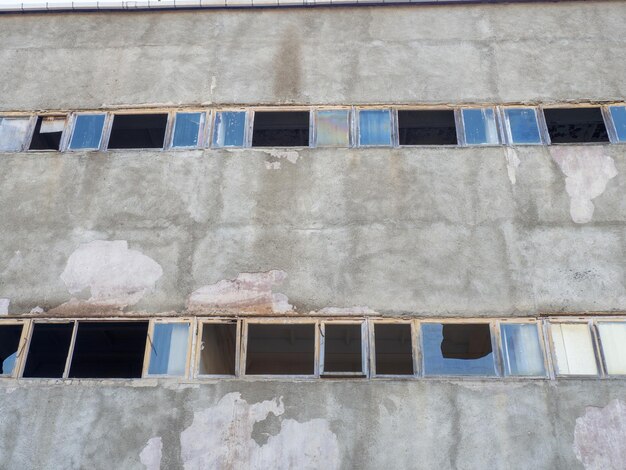 Velho edifício industrial abandonado, janelas quebradas.