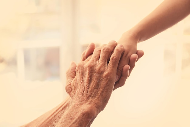 Velho homem e jovem mãos femininas closeup