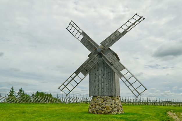 Velho moinho de madeira vintage com o céu nublado. Saaremaa, Estônia.