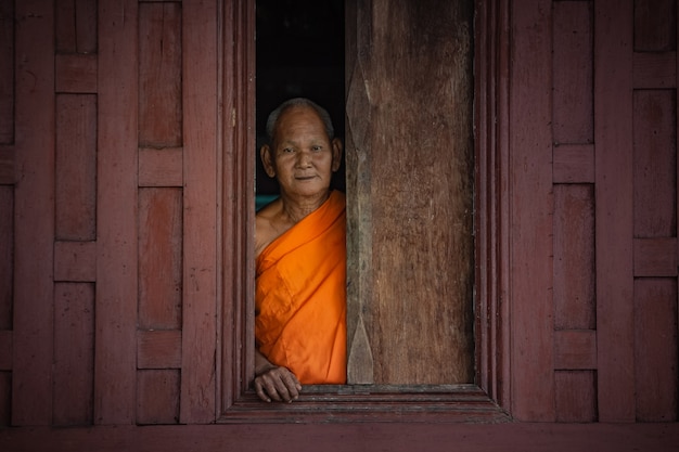 Velho monge parado na janela