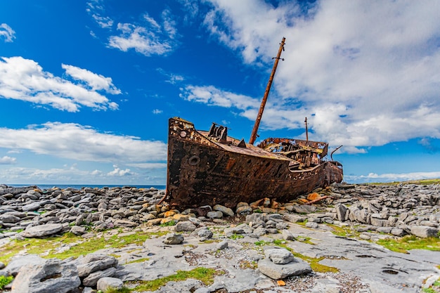 Velho navio de carga abandonado Plassey na praia rochosa contra o céu azul na ilha de Aran, Irlanda