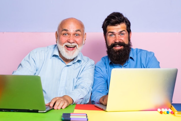 Velho pai e filho usando notebook Trabalhadores do sexo masculino conversando na mesa do escritório reunindo-se com a Família Multigeração Masculina usando a Internet