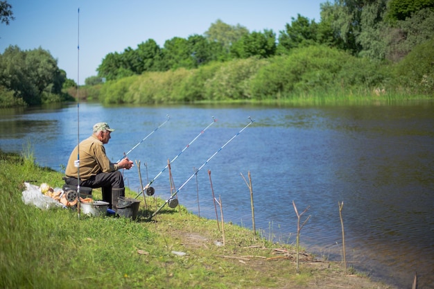 Velho pescador pega peixe no lago