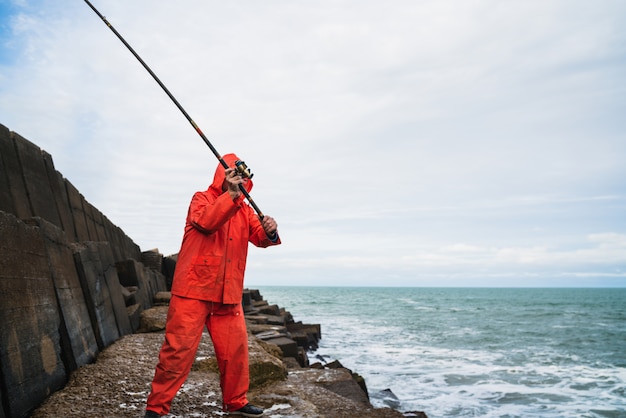 Velho pescando no mar.