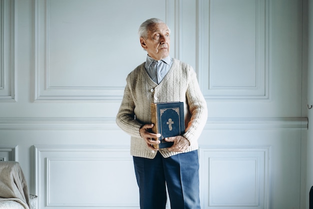 Velho segurando um livro